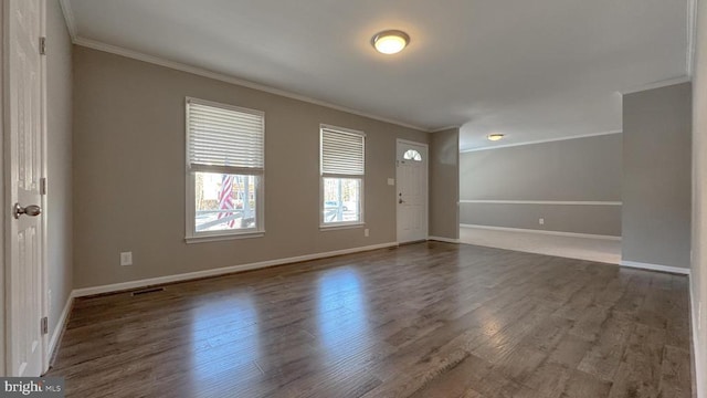 foyer with ornamental molding and dark hardwood / wood-style floors