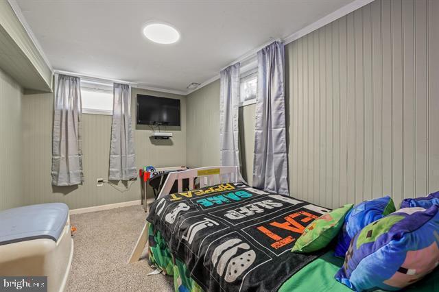 bedroom with baseboards, carpet flooring, and crown molding