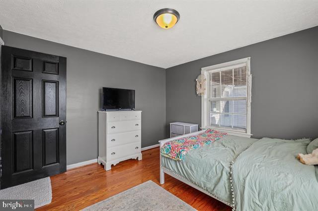 bedroom with baseboards and wood finished floors