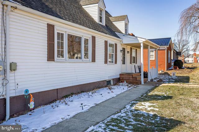 view of snowy exterior featuring a shingled roof