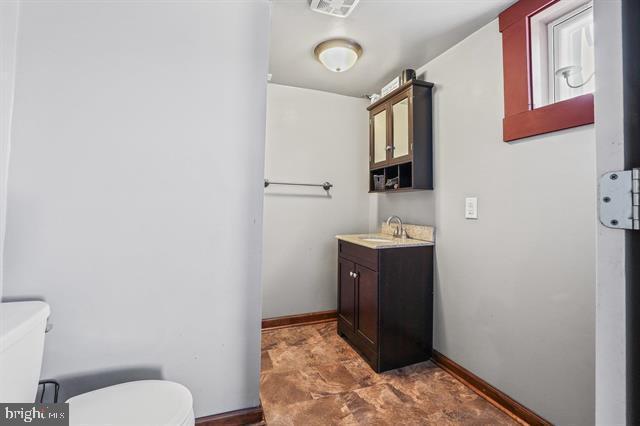 bathroom with toilet, visible vents, baseboards, and vanity