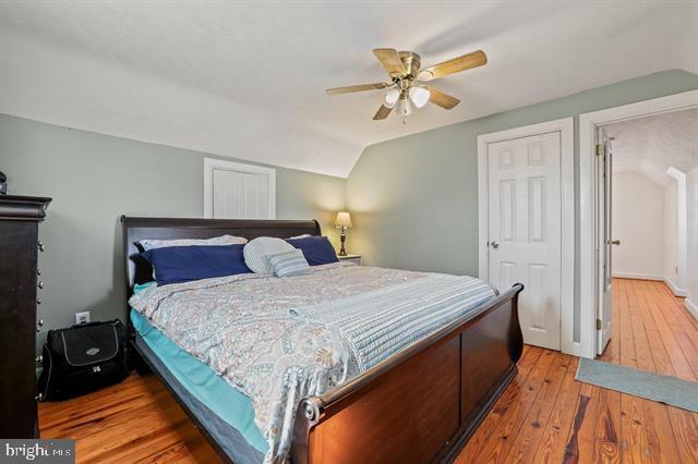 bedroom featuring a ceiling fan, lofted ceiling, and hardwood / wood-style flooring