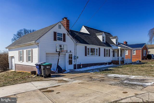 exterior space featuring a garage, driveway, and a chimney