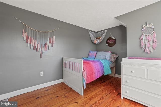 bedroom with wood finished floors and baseboards