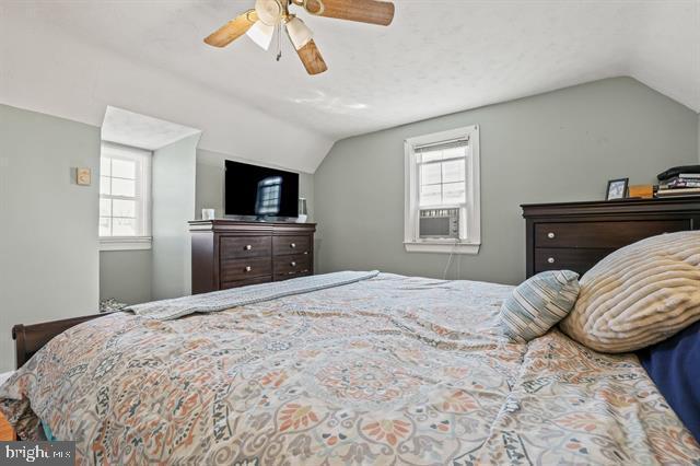 bedroom featuring multiple windows, vaulted ceiling, and ceiling fan