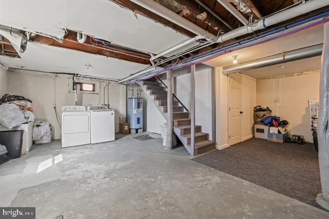 below grade area with washing machine and dryer, stairway, and electric water heater