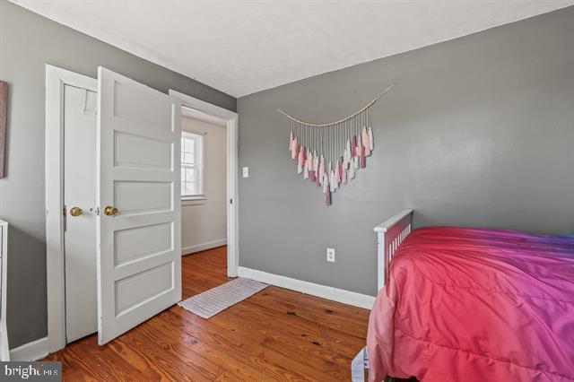 bedroom with baseboards and wood finished floors