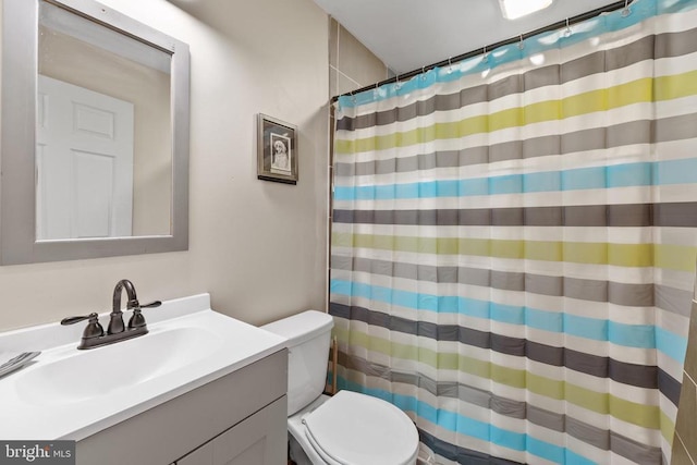 full bathroom featuring toilet, curtained shower, and vanity