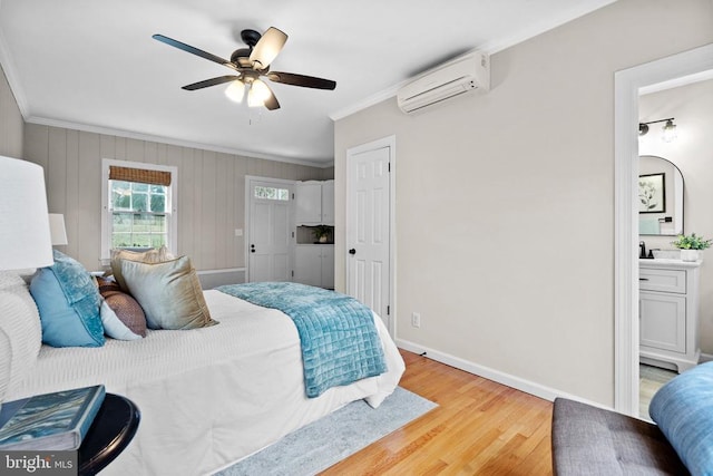 bedroom featuring ornamental molding, light wood-type flooring, ceiling fan, and a wall unit AC