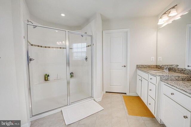 bathroom with vanity, an enclosed shower, and tile patterned floors