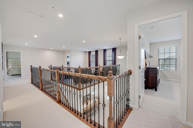 hallway featuring light colored carpet