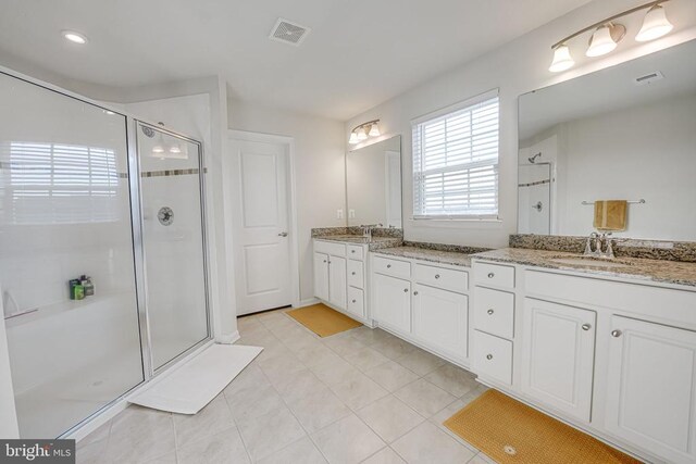 bathroom featuring vanity, tile patterned flooring, and a shower with shower door