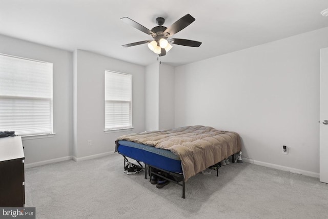 carpeted bedroom featuring baseboards and a ceiling fan