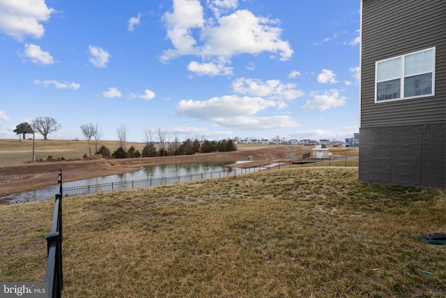 view of yard with a water view and fence