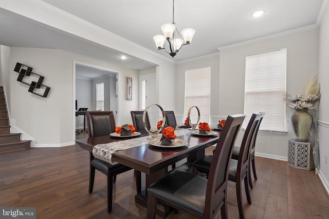 dining space featuring crown molding, dark wood-type flooring, a chandelier, baseboards, and stairs