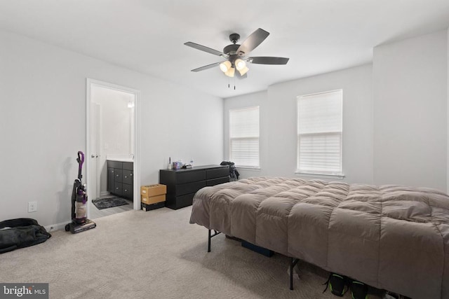 bedroom with carpet floors, connected bathroom, and a ceiling fan