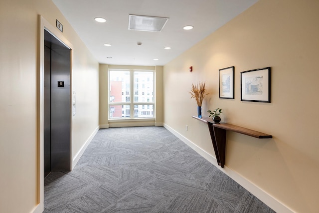 corridor featuring recessed lighting, baseboards, elevator, and carpet