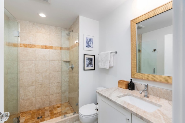 bathroom featuring vanity, toilet, and a stall shower
