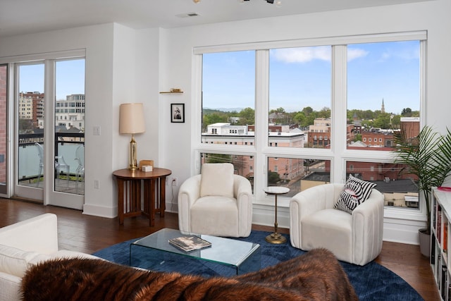 living area with wood finished floors, visible vents, and baseboards