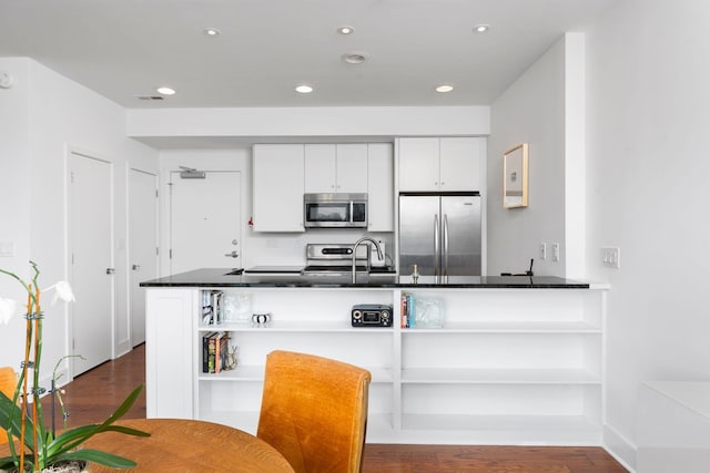 kitchen with open shelves, appliances with stainless steel finishes, dark wood-style floors, and a sink