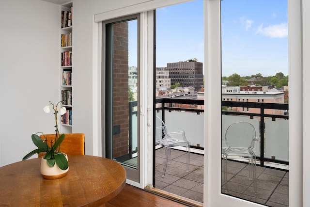 doorway to outside featuring wood finished floors, built in features, and a view of city