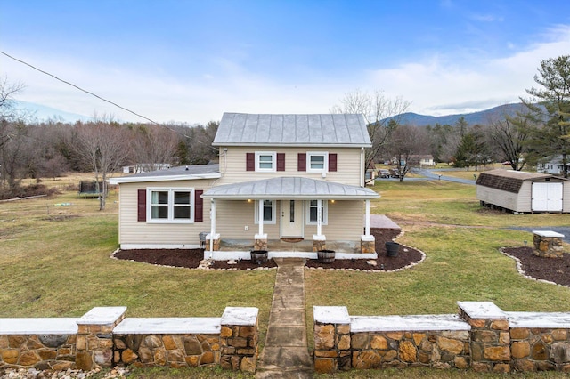 view of front of property with a shed, a mountain view, covered porch, and a front lawn