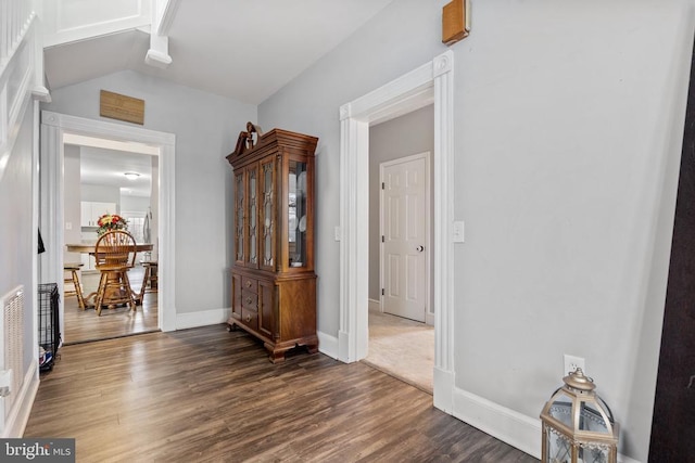 hall featuring lofted ceiling and dark hardwood / wood-style floors