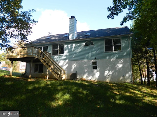 rear view of house featuring cooling unit, a lawn, a deck, and stairs