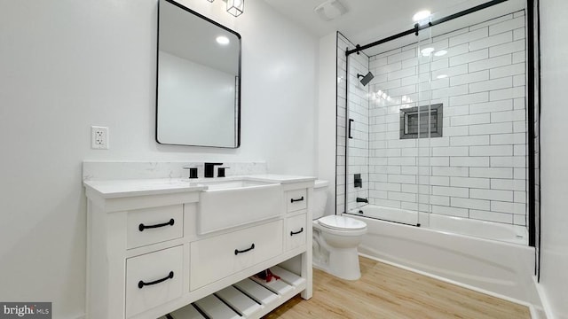 full bathroom with vanity, wood-type flooring, toilet, and tiled shower / bath