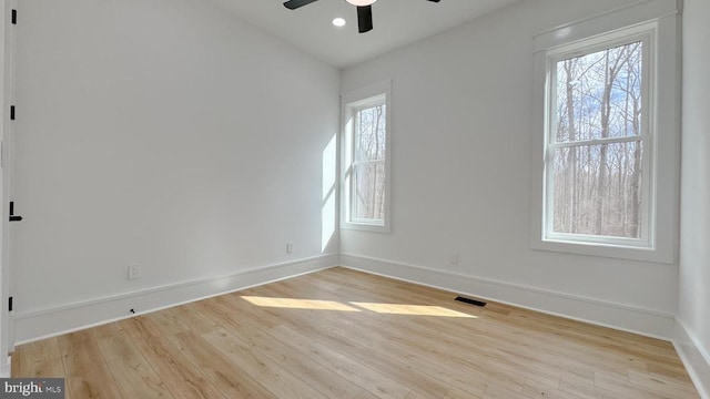 unfurnished room with baseboards, visible vents, and wood finished floors