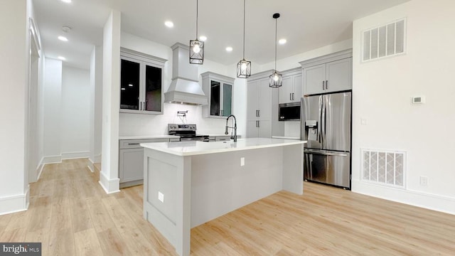 kitchen with appliances with stainless steel finishes, visible vents, a sink, and custom exhaust hood