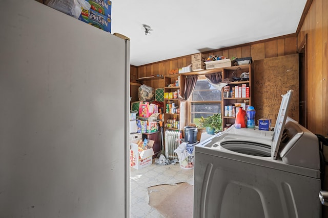 laundry room featuring laundry area, wood walls, tile patterned floors, and washer / dryer