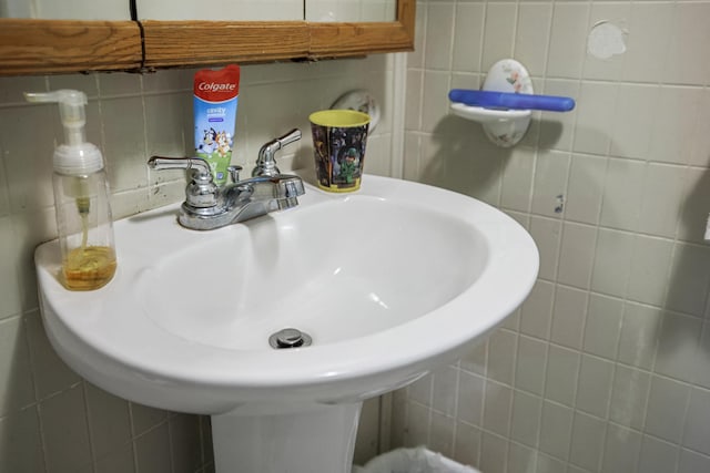 bathroom with a sink and tile walls