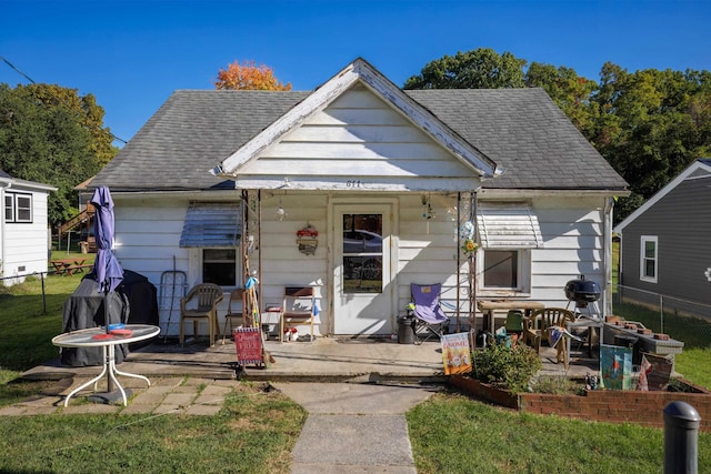 bungalow-style house featuring roof with shingles, a patio, and fence