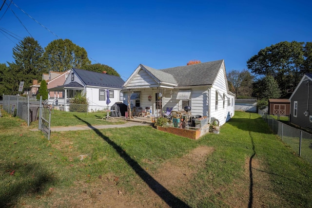 back of house featuring a yard, a patio, roof with shingles, and a fenced backyard