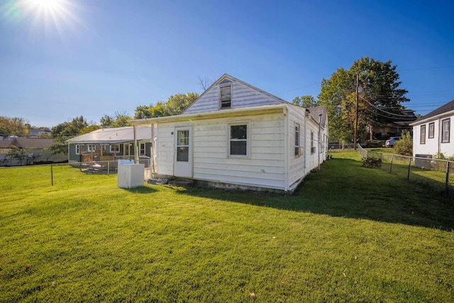 rear view of property featuring a yard and a fenced backyard