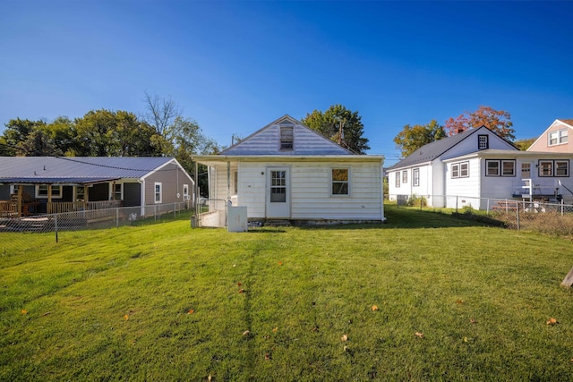 rear view of house featuring a fenced backyard and a yard