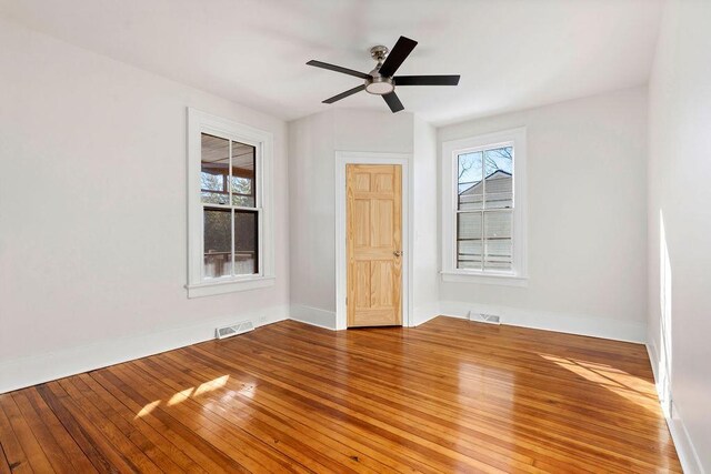 empty room with hardwood / wood-style flooring and ceiling fan