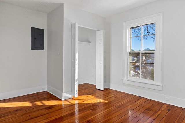 empty room with wood-type flooring and electric panel