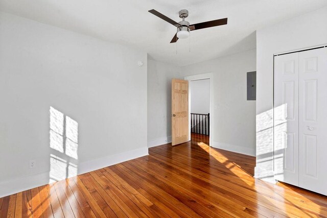 unfurnished room with hardwood / wood-style flooring, ceiling fan, and electric panel