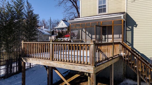 snow covered deck with a sunroom