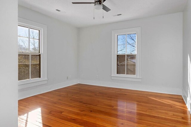 empty room with hardwood / wood-style flooring and ceiling fan