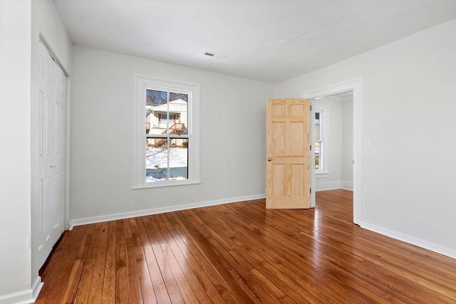 unfurnished bedroom featuring wood-type flooring and a closet