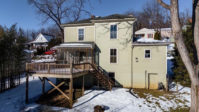 snow covered house featuring a deck