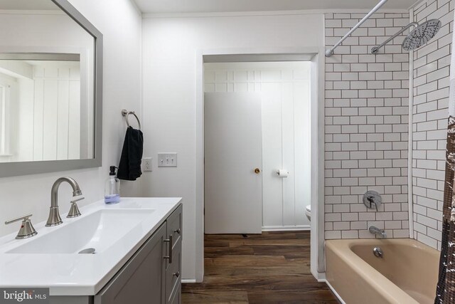 bathroom featuring toilet, shower / tub combo, wood finished floors, and vanity