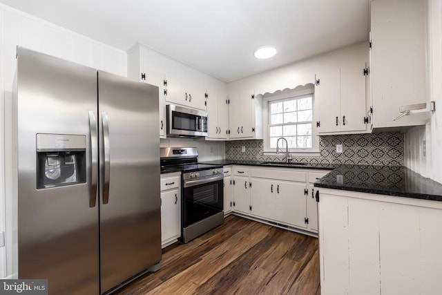 kitchen with white cabinetry, appliances with stainless steel finishes, decorative backsplash, and a sink