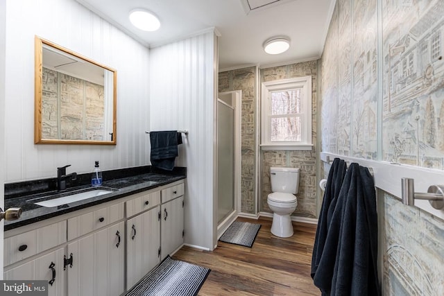 full bath featuring a stall shower, vanity, toilet, and wood finished floors