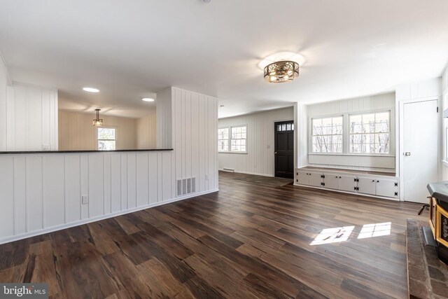 unfurnished living room featuring dark wood finished floors, visible vents, and recessed lighting