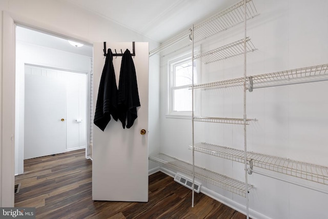 mudroom featuring vaulted ceiling, dark wood-style flooring, and visible vents