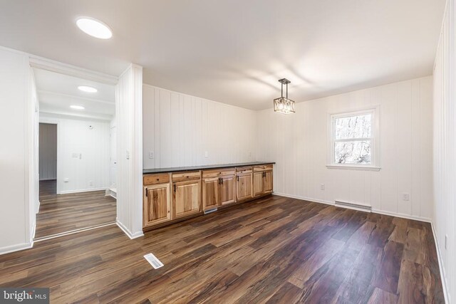 spare room featuring visible vents, baseboards, dark wood-type flooring, a baseboard heating unit, and a notable chandelier